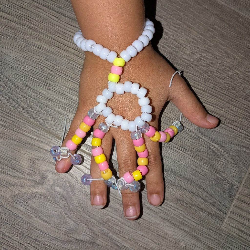 Hand wearing a colorful beaded bracelet on a wooden floor
