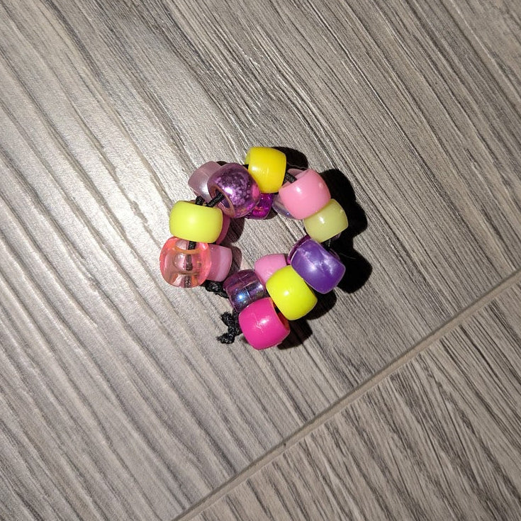 Colorful beaded hair tie on a wooden floor