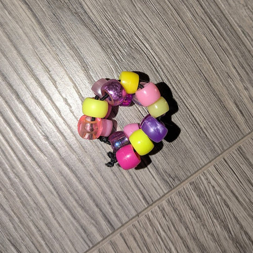 Colorful beaded hair tie on a wooden floor