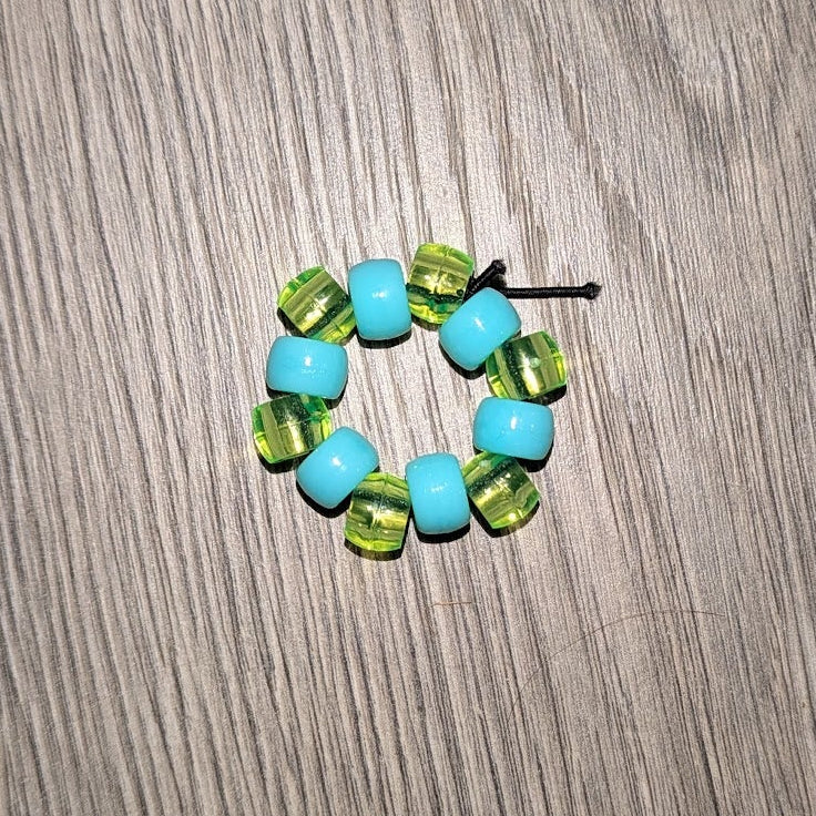 Colorful beaded hair tie on a wooden surface