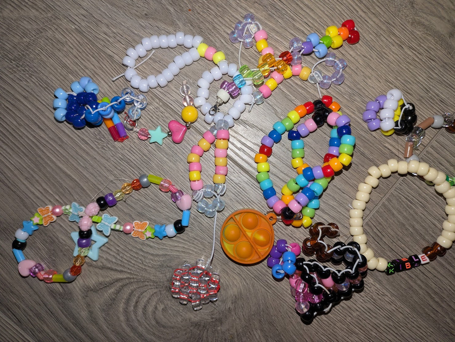 Colorful beaded bracelets and keychains on a wooden surface