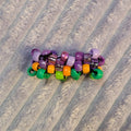 Colorful beaded hair clip on a striped fabric background