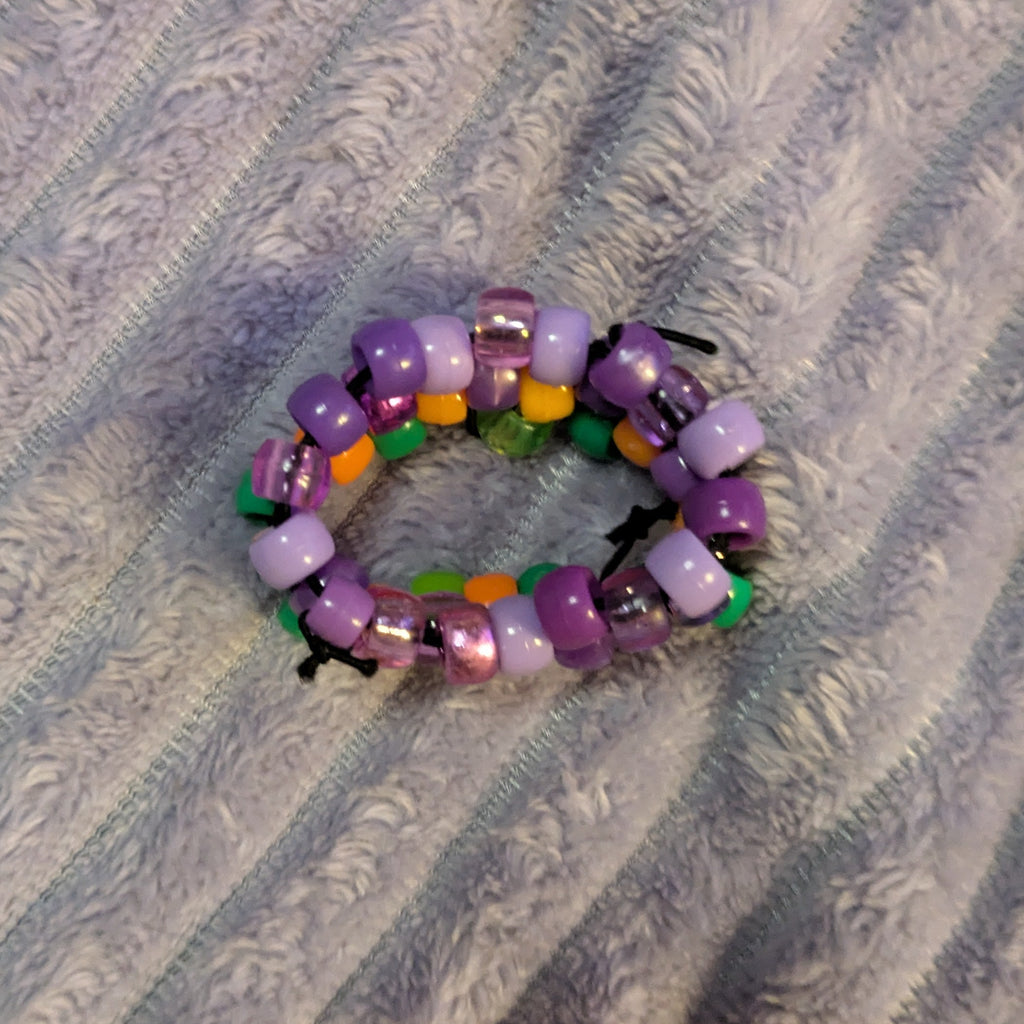 Multicolored beaded ring on a textured gray surface