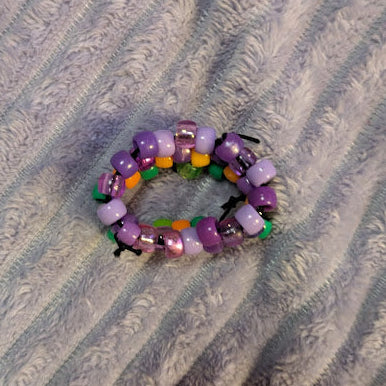 Multicolored beaded ring on a textured gray surface
